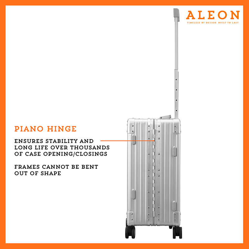 A polished silver platinum aluminum ALEON 21" Carry-On stands upright on a glossy airport floor, reflecting ambient lighting. Its durable, hard-shell construction and smooth wheels embody modern travel efficiency.