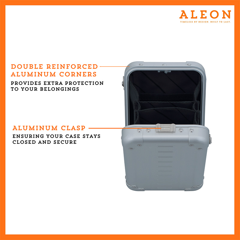 ALEON vertical crossbody case displayed with highlighted features, including double reinforced aluminum corners for enhanced durability and an aluminum clasp for secure closure. The case is open, revealing organized interior compartments. Brand name 'ALEON' and tagline 'TIMELESS BY DESIGN. BUILT TO LAST.' are shown at the top right.
